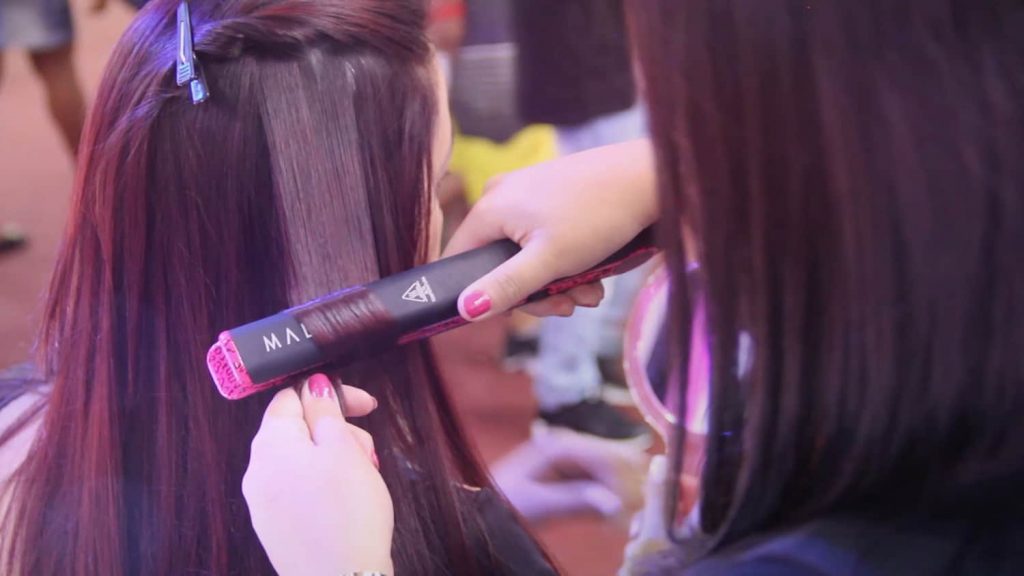 girl learning how to curl your hair with a straightener